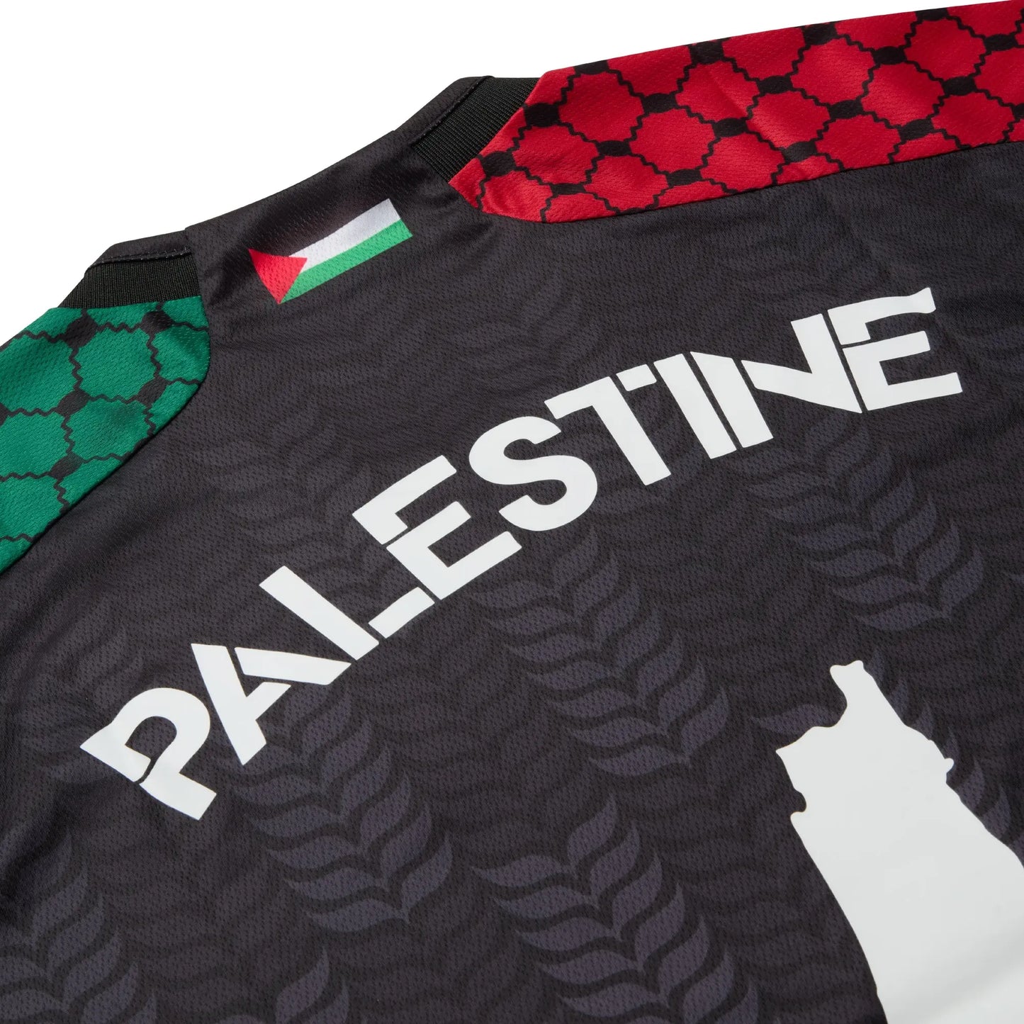 Close-up of the Palestine lettering and rear neckline on the black TRG Kids football jersey.