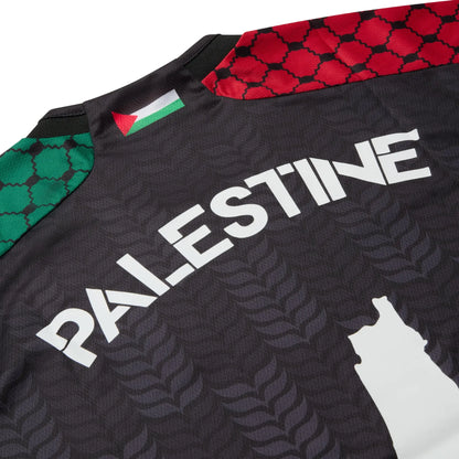 Close-up of the Palestine lettering and rear neckline on the black TRG Kids football jersey.