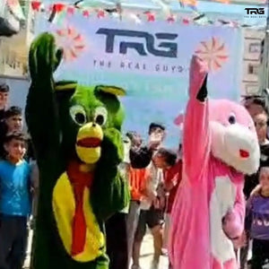The Real Guys children's fun day in Gaza with mascot costumes and children celebrating Eid