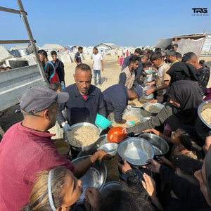 Families receiving hot food at meal distribution in Gaza displacement camp by The Real Guys
