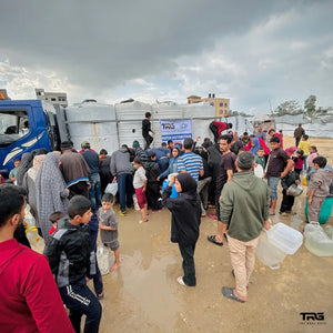 Large crowd of families and children gathering for The Real Guys water distribution in Gaza