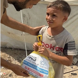 Boy receiving The Real Guys and Al-Qulub Trust hot meals distribution bag in North Gaza