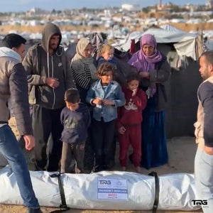 Family with young children receiving The Real Guys emergency response package at displacement camp in Gaza