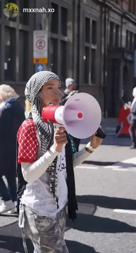 Woman wearing Palestine football t-shirt white at protest rally