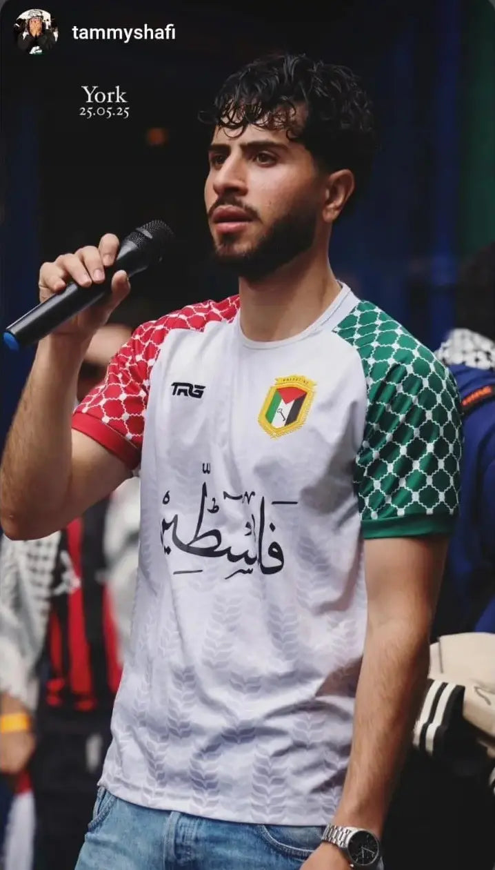 Man wearing Palestine football jersey white speaking on stage at event in York