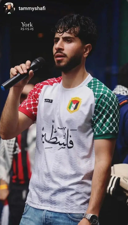 Man wearing Palestine football jersey white speaking on stage at event in York