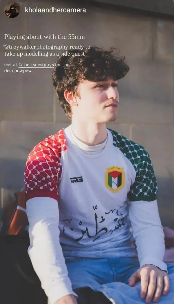 Man wearing Palestine football jersey white long sleeve with Arabic calligraphy photographed by khоlaandhercamera