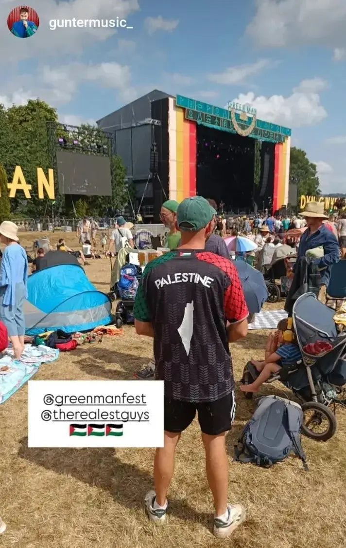 Man wearing Palestine football jersey black back view showing Palestine map at Green Man Festival