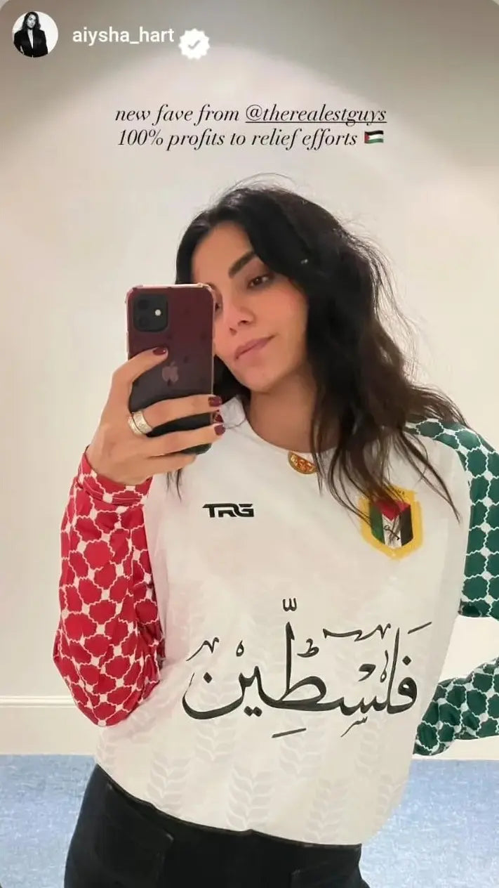 Aiysha Hart wearing Palestine football jersey white long sleeve mirror selfie 100 percent profits to relief efforts